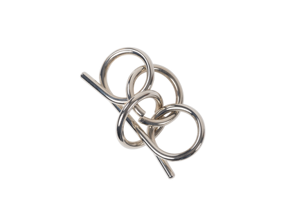 Silver wire puzzle (disentanglement puzzle) consisting of three interconnected loops against a black background