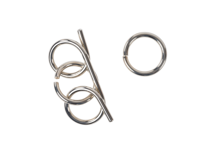 Silver wire disentanglement puzzle (rod and loops) and a separate ring on a black background