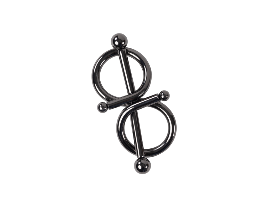 Dark metal figure-eight body jewelry clamp with two rings and spherical ends, against a black background