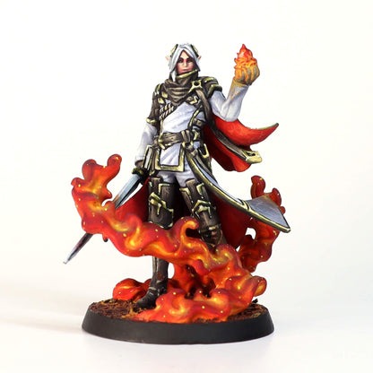 Elven miniature with white hair, armor, red cape, conjuring fire in one hand, standing in flames.