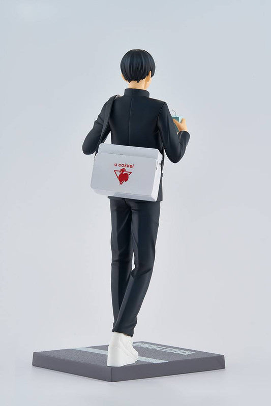 Rear view of a Black Clover Yuno figure in a black suit holding a drink and carrying a white shoulder bag