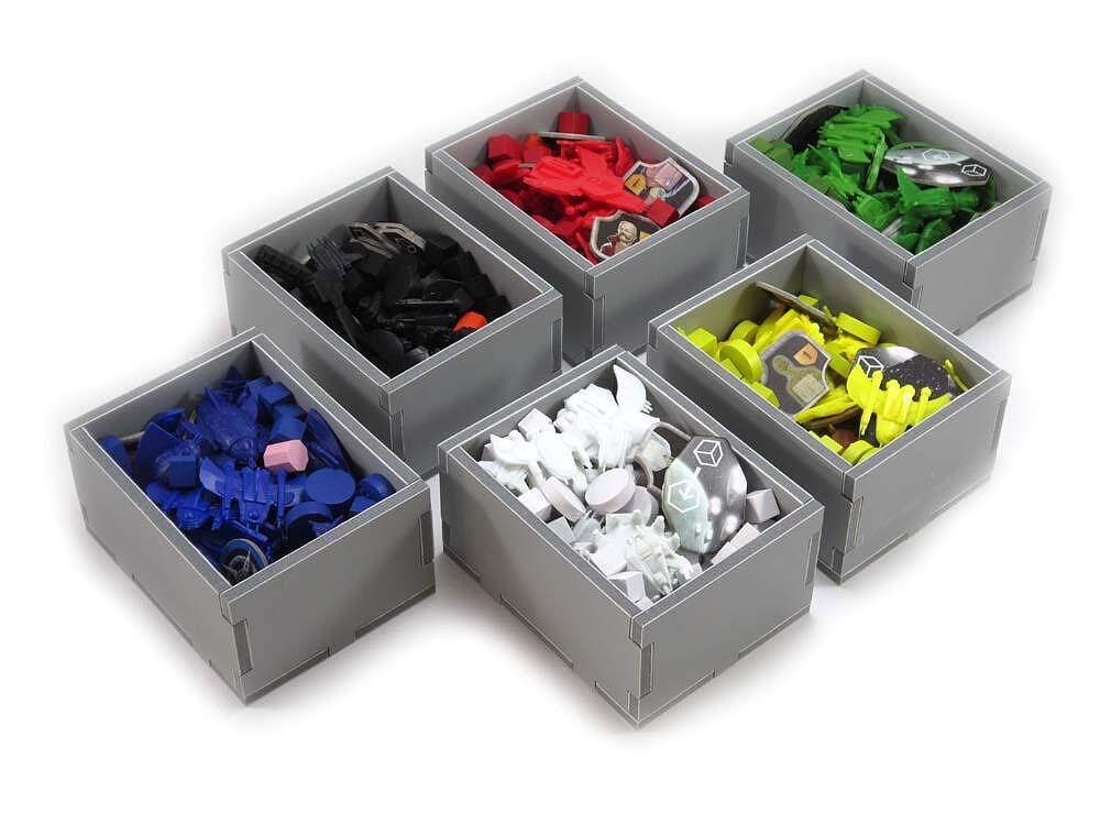 Seven grey boxes filled with different colored board game pieces