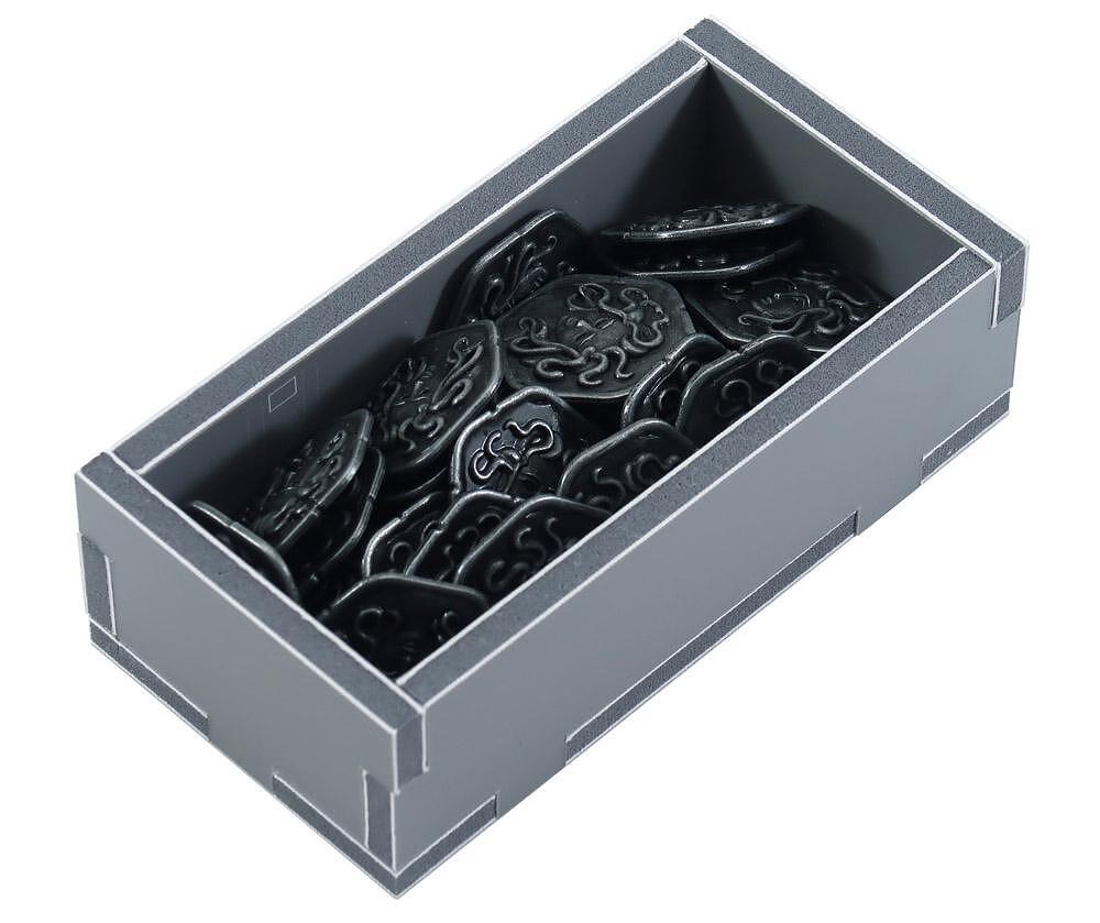 Gray organizer box with black square game tokens, angled view