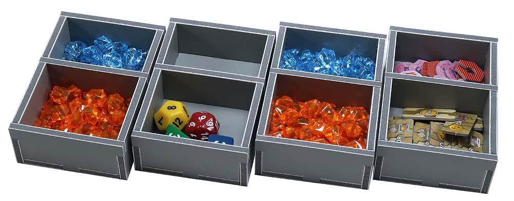 Eight gray modular trays hold board game pieces: blue/orange gems, dice, pink, and wooden tokens