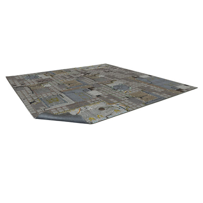 A gray sci-fi gaming mat featuring industrial metal panels and yellow hazard stripes, with one corner slightly lifted.