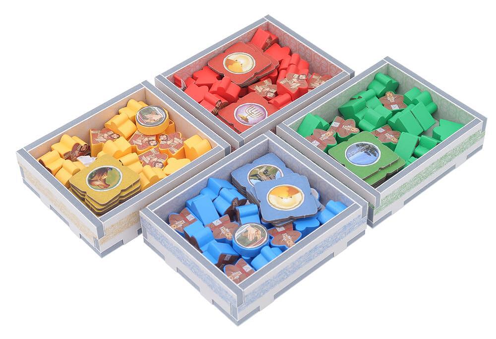 Four board game component boxes in red, yellow, blue, and green, filled with pieces.