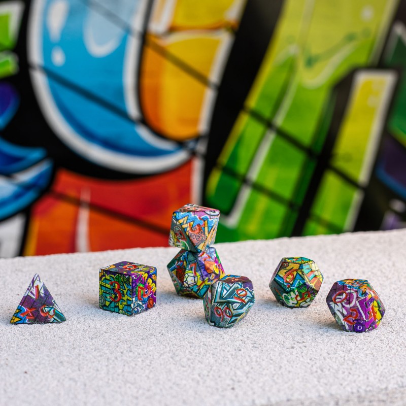 Seven colorful, graffiti-patterned polyhedral dice, including one stack, on concrete, against a blurred vibrant graffiti wall