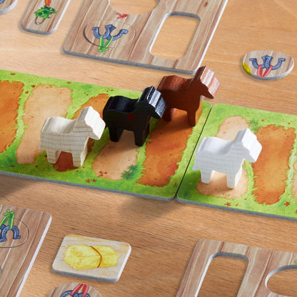 Wooden animal figures (horses, sheep) on a colourful farm-themed board game path. Other game tokens are visible.