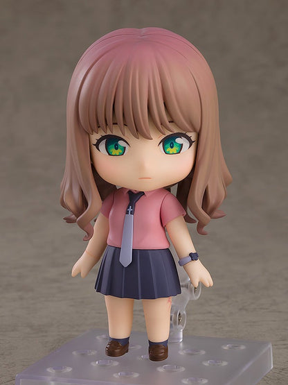 Nendoroid doll of a girl with brown hair pink shirt blue skirt and brown shoes on color background