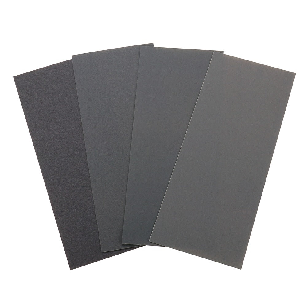 Four sheets of varying grit sandpaper, fanned out in shades of gray