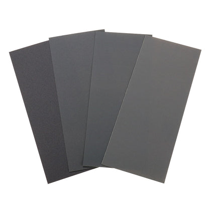 Four sheets of varying grit sandpaper, fanned out in shades of gray