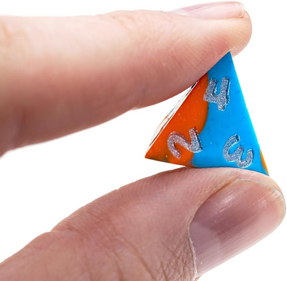 A hand grips a blue and orange Anti-Stress Dice D4, displaying silver numbers 2, 3, and 4