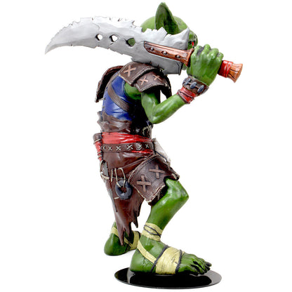 Green goblin figurine in brown armor and red sash, holding a large serrated sword over its shoulder