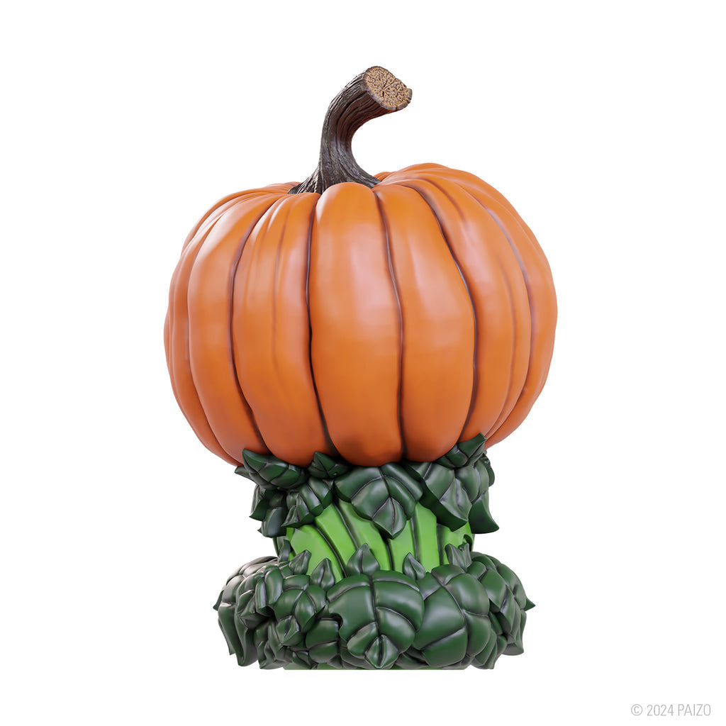 A vibrant orange gourd leshy figure with a brown stem sits on a base of sculpted dark green leaves