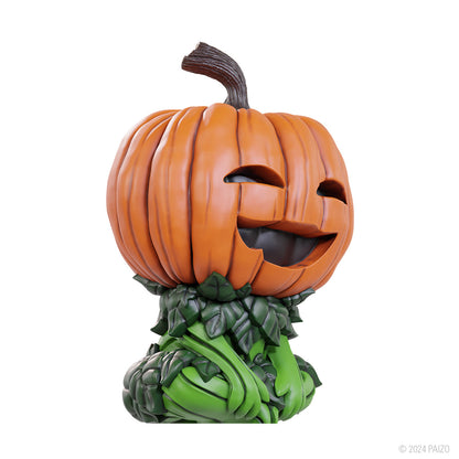 A carved orange gourd leshy figure with a smiling face, brown stem, and a body made of green leaves and vines