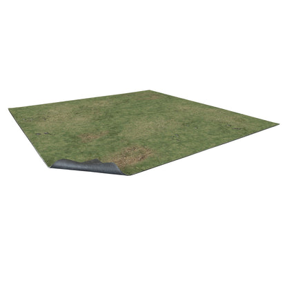 A square mat with a green grass texture and dirt patches, one corner lifted to show its dark, ridged underside.
