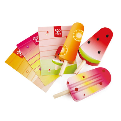 Set of three colorful wooden play popsicles (watermelon, orange, and mixed fruit) with branded Hape game cards