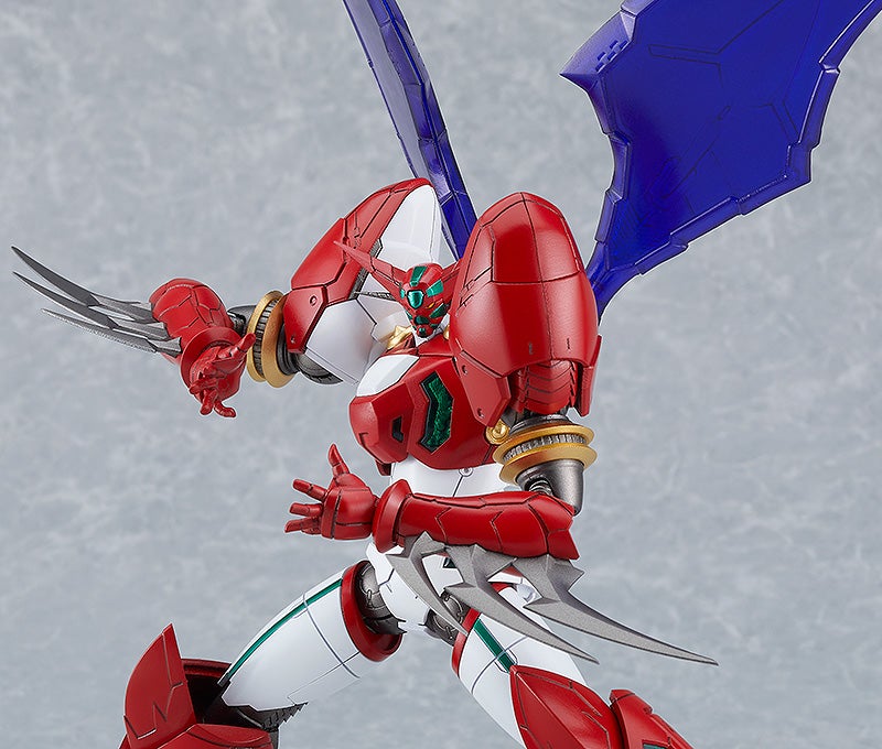 A red and white robot with green visor, blue wings, and sharp blades on its forearms and leg, posed dynamically