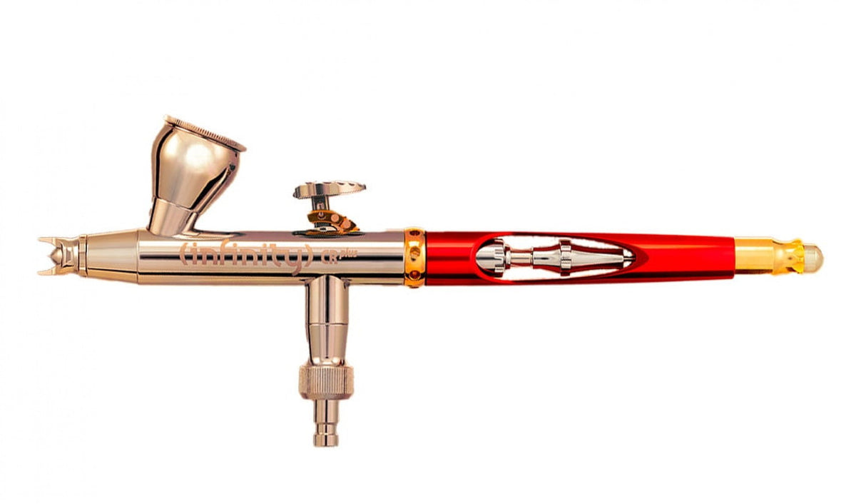 Polished silver and red Infinity CR Plus airbrush with a top-mounted paint cup, on a white background