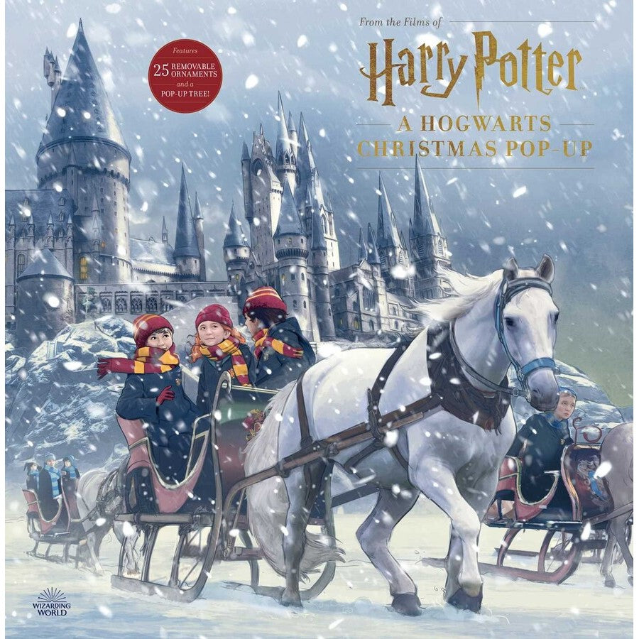 A Harry Potter Christmas pop-up book cover: Snowy Hogwarts Castle, students in horse-drawn sleds, with snow falling