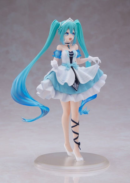 Side view of hatsune Miku figure in a short, layered blue and white dress, tiara, and flowing teal pigtails on a display stand