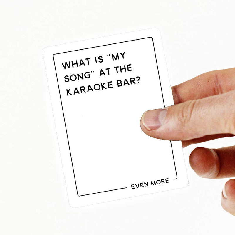Hand holding a white card with the question WHAT IS MY SONG AT THE KARAOKE BAR