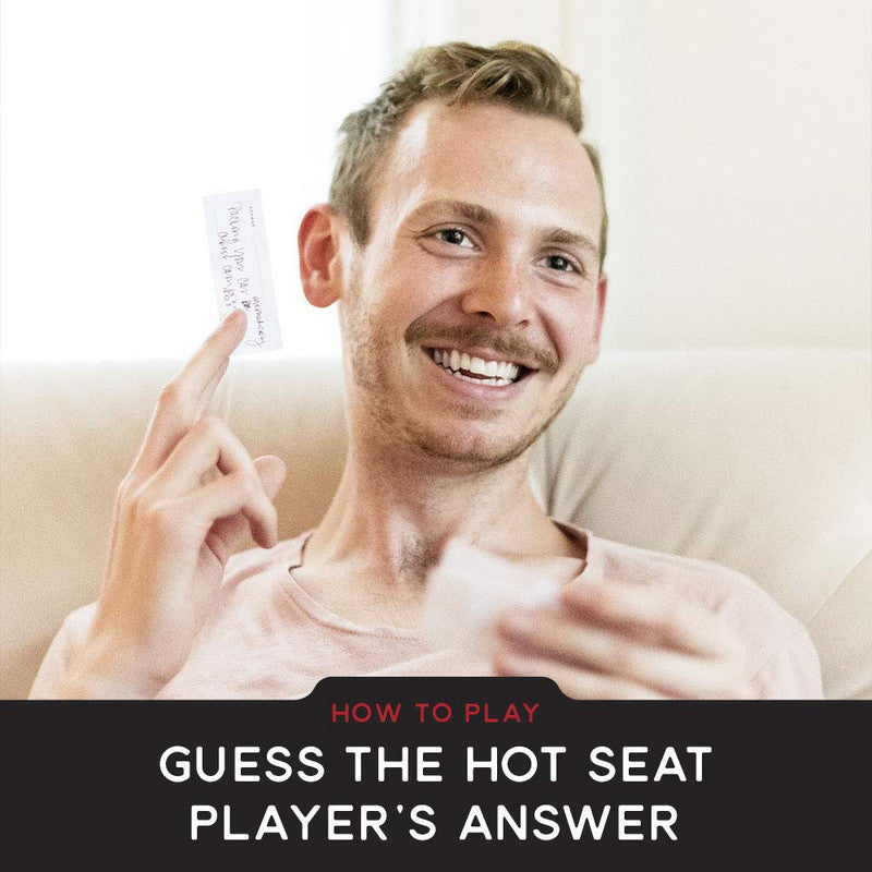 Man smiling and holding up a card with handwritten text playing a game dark overlay says How To Play Guess The Hot Seat Player&#39;s Answer