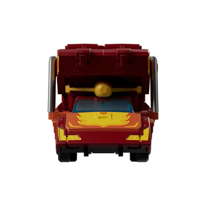 Front view of a red and yellow Hot Rod/Rodimus Prime Transformer toy in vehicle mode with an attached trailer