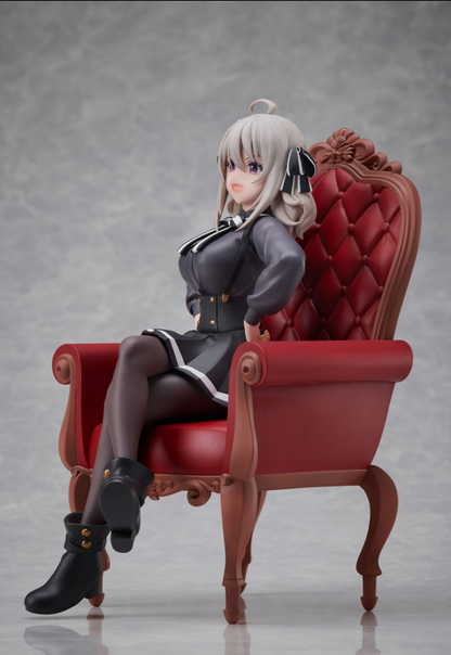 Side view of anime figure of a girl with silver hair wearing a black dress and boots sitting in a red armchair