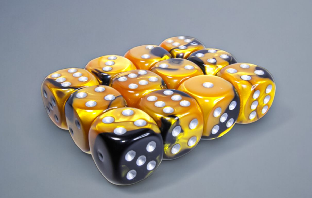 Twelve gold and black marbled dice with silver pips are clustered on a gray surface