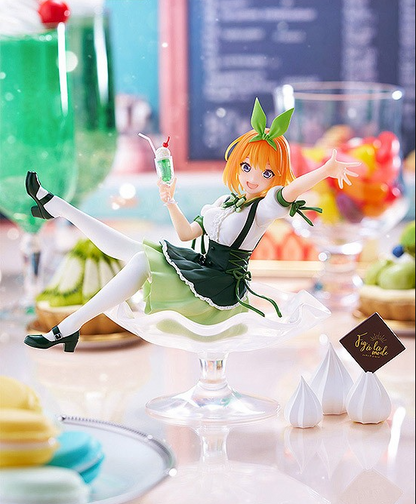 Anime figure in a green maid dress sitting in a glass dessert bowl holding a drink