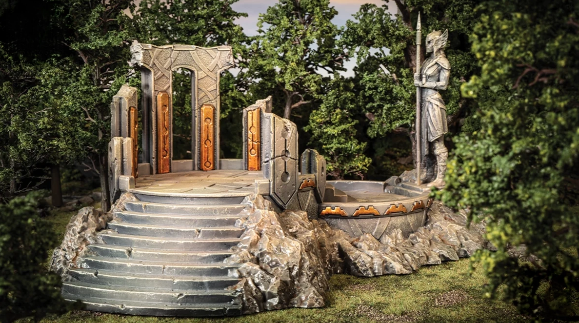 Detailed miniature stone ruins: stairs leading to an archway and a spear-wielding warrior statue set in a dense forest