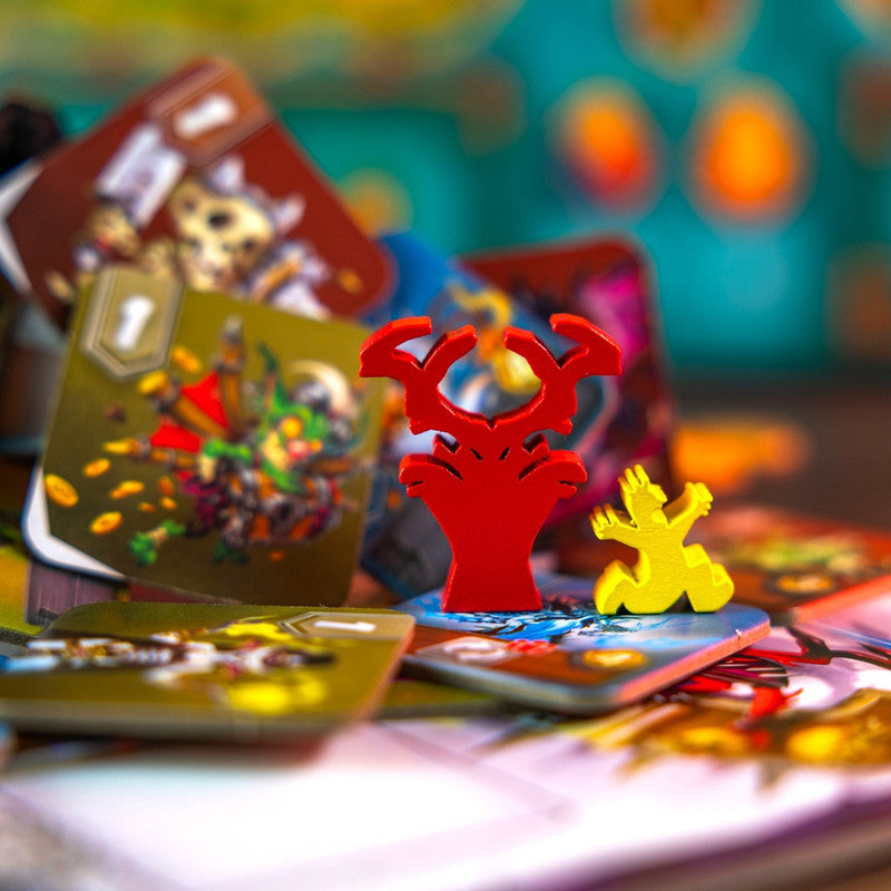 Colorful board game pieces including red antlers and a yellow figure on game cards