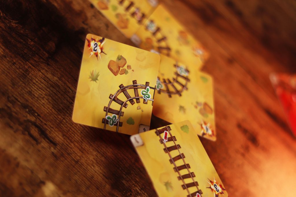 Players strategizing in Infernal Wagon card game during play