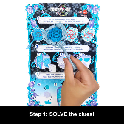 Hand uses a blue wand on a Monster High Ultimate Secret Mysteries game board, revealing clues on heart and skull shapes, blue and purple floral border. "Solve the clues!"