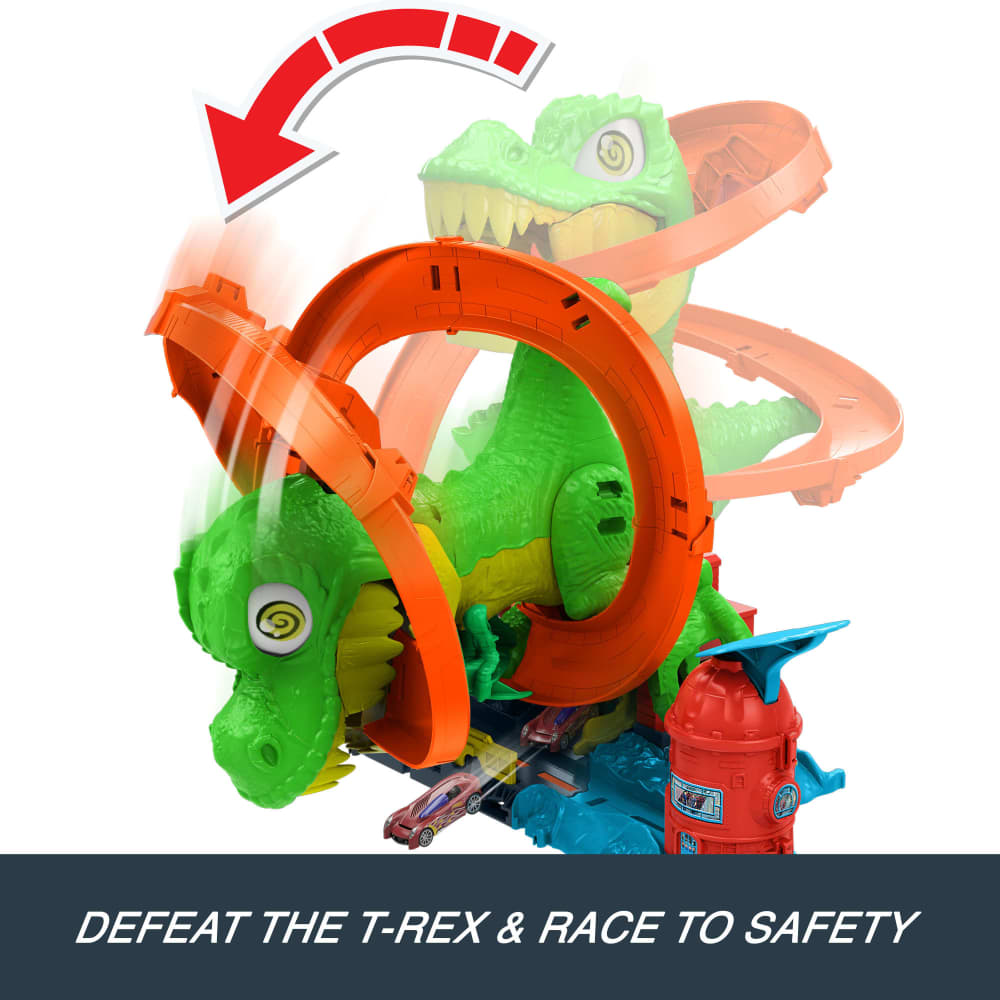 Green toy T-Rex attacking an orange Hot Wheels-style track loop with toy cars