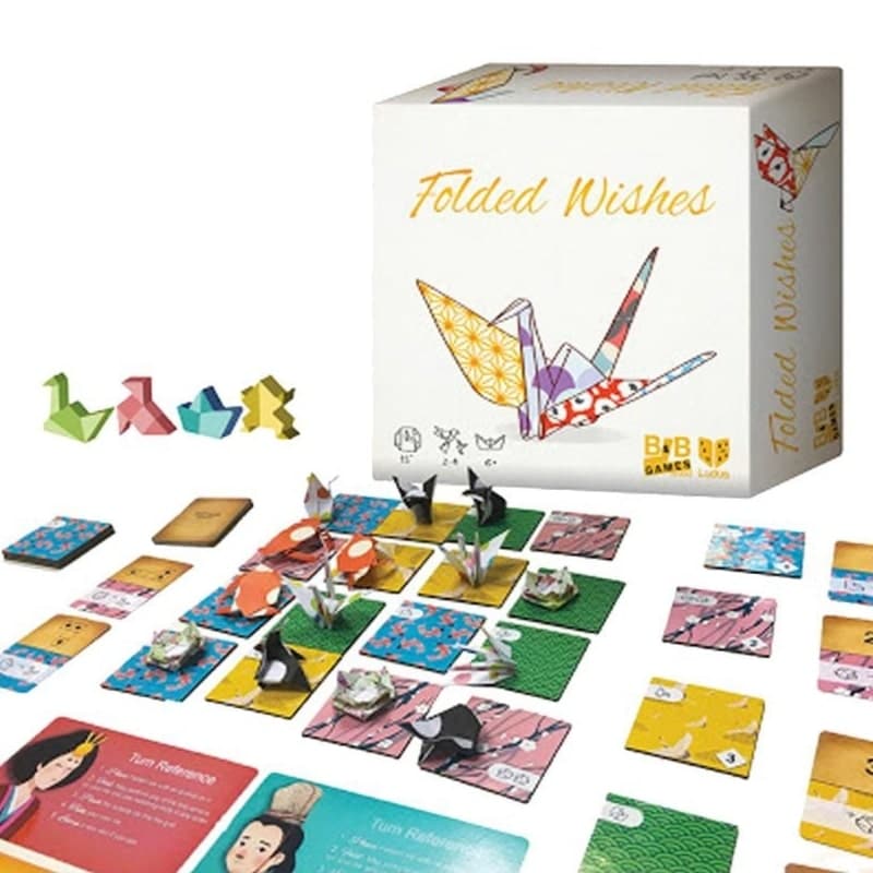 A "Folded Wishes" board game setup. Its box with an origami crane, colorful game pieces, cards, and tiles are displayed.