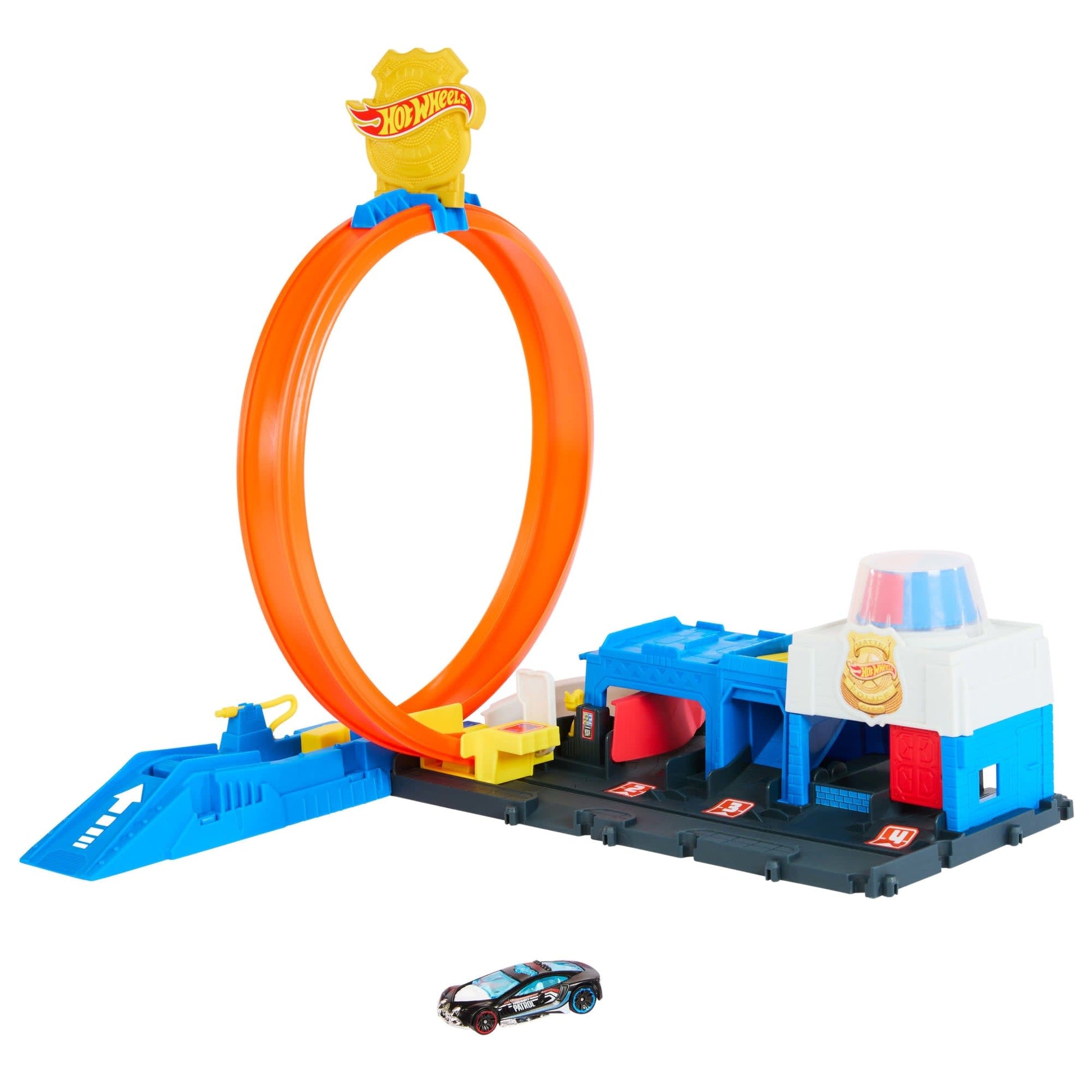 A Hot Wheels playset with an orange loop track, a blue launcher, a police station building, and a black toy car