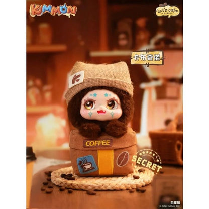 A cute, furry Kimmon figure wearing a burlap beanie, emerging from a brown cube labeled "COFFEE" in a cafe