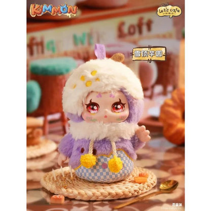 Stylized Kimmon collectible figure in a fuzzy purple jacket and white hood, posed in a cafe setting