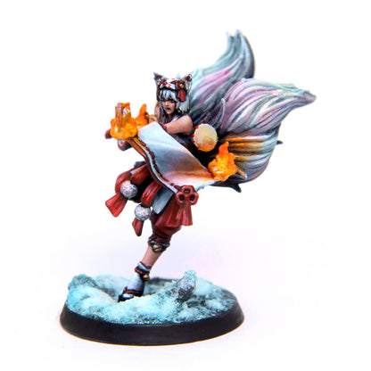 Hand-painted miniature of a white-haired kitsune in red and white, casting fire magic on a snowy base.