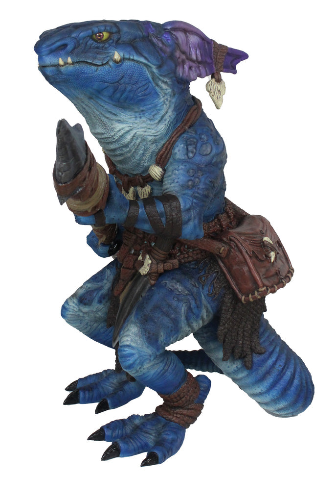 Crouching blue reptilian kobold figure with yellow eyes, holding a blade. Wears leather straps and a hip pouch