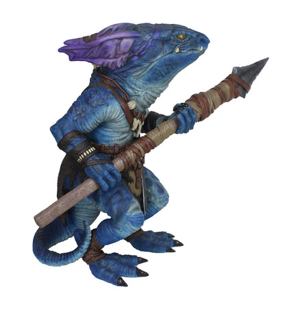 A blue, kobold figure with purple head fins and yellow eyes stands, holding a primitive spear