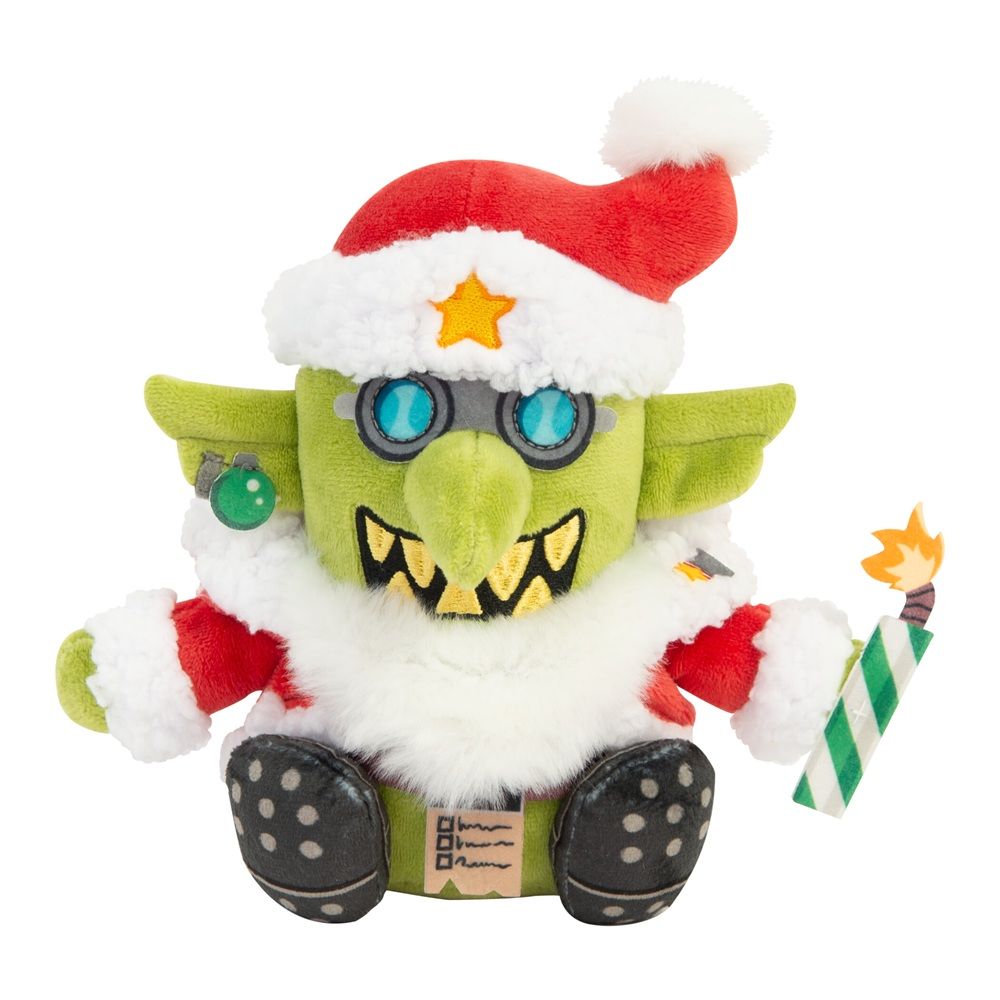 Green goblin plush wearing a Santa hat and goggles, holding a striped, lit firecracker