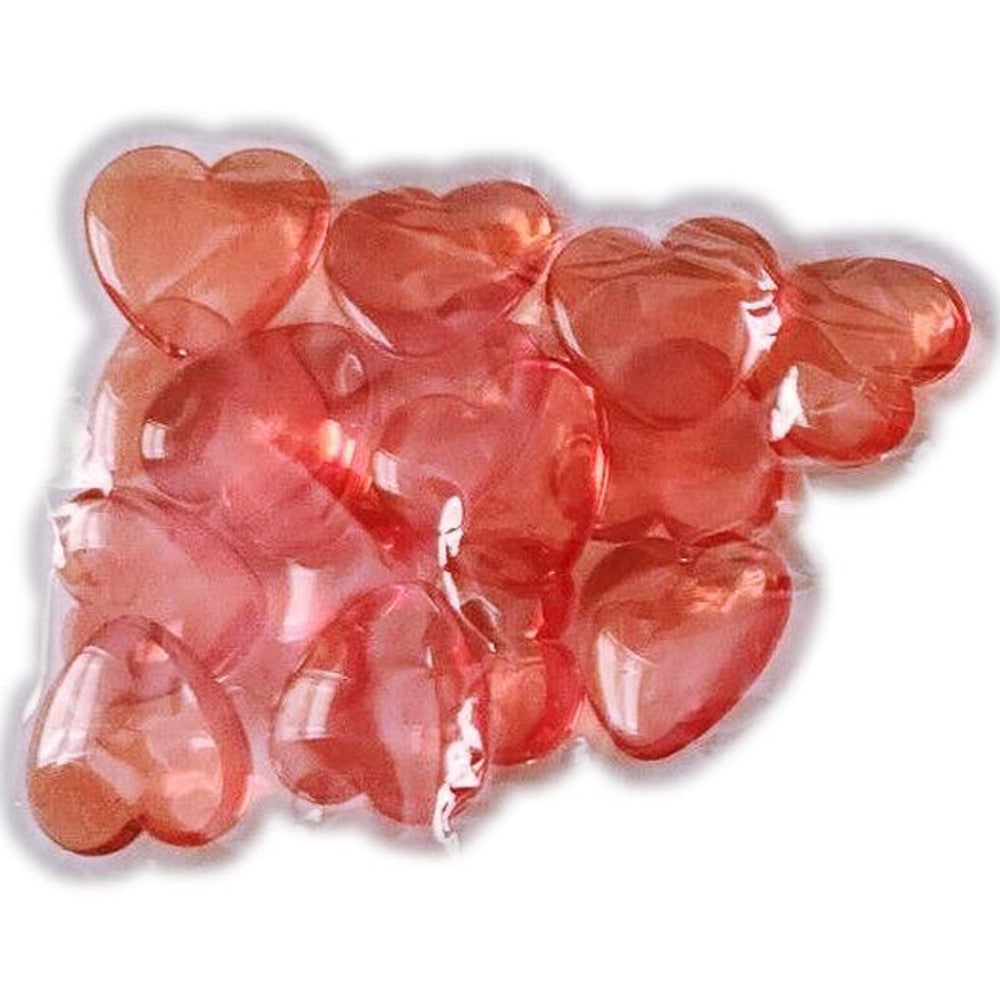 Shiny, translucent reddish-pink heart-shaped objects, grouped together.