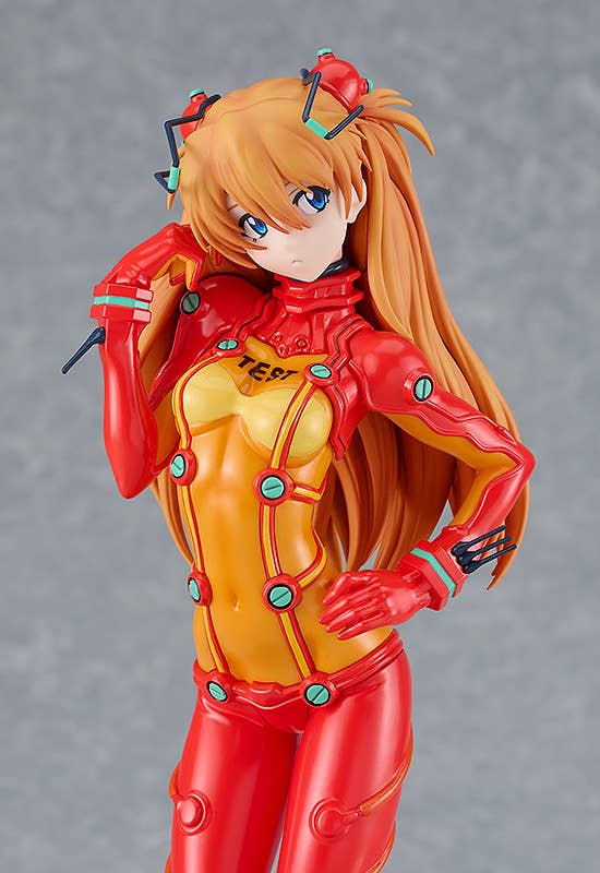 Asuka anime figure in a red and orange plugsuit, featuring long orange hair and an arm raised to her head