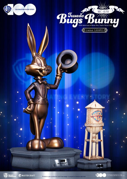 Limited edition bronze statue of Tuxedo Bugs Bunny tipping his hat standing beside a miniature Warner Bros water tower on a stone base