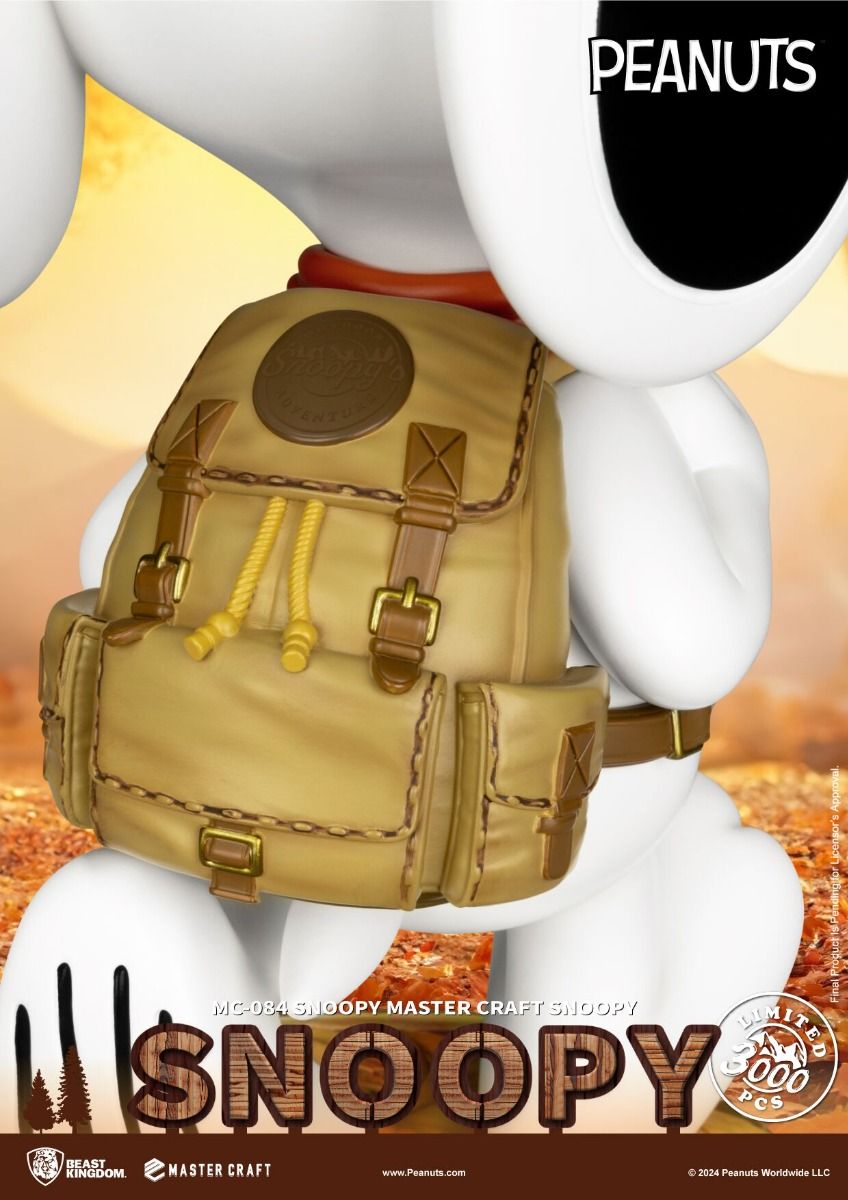Large white figurine of Snoopy wearing an orange scarf and tan hiking backpack in an outdoor setting