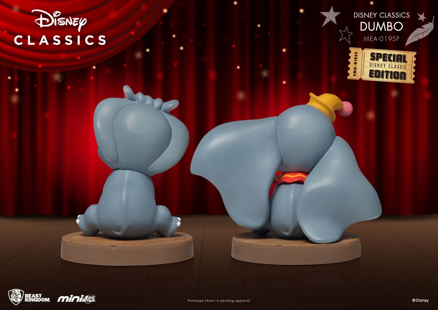 Two Dumbo figures from Disney Classics one sitting and one on its belly with trunk extended on brown bases