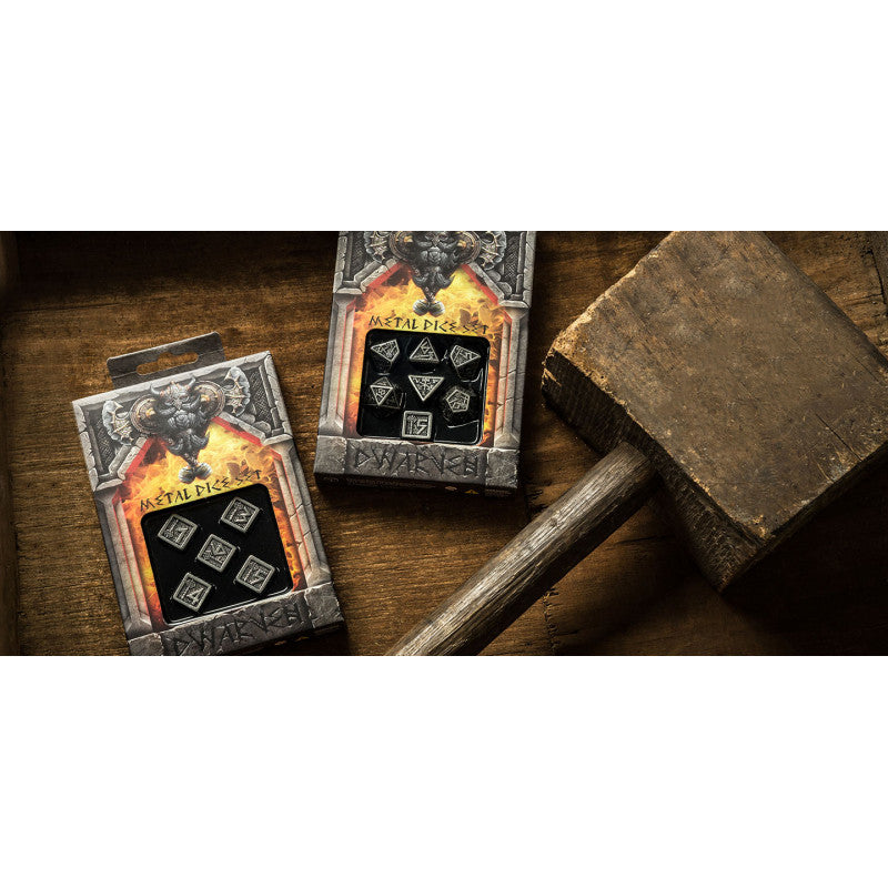 Two &quot;Dwarven Metal Dice Sets&quot; in fiery packaging, with dark metal dice visible, placed on wood next to a large mallet